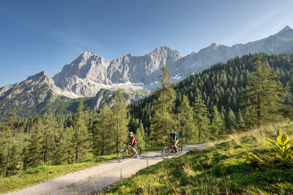 Mountainbiker vor dem Dachsteinmassiv im Sommer